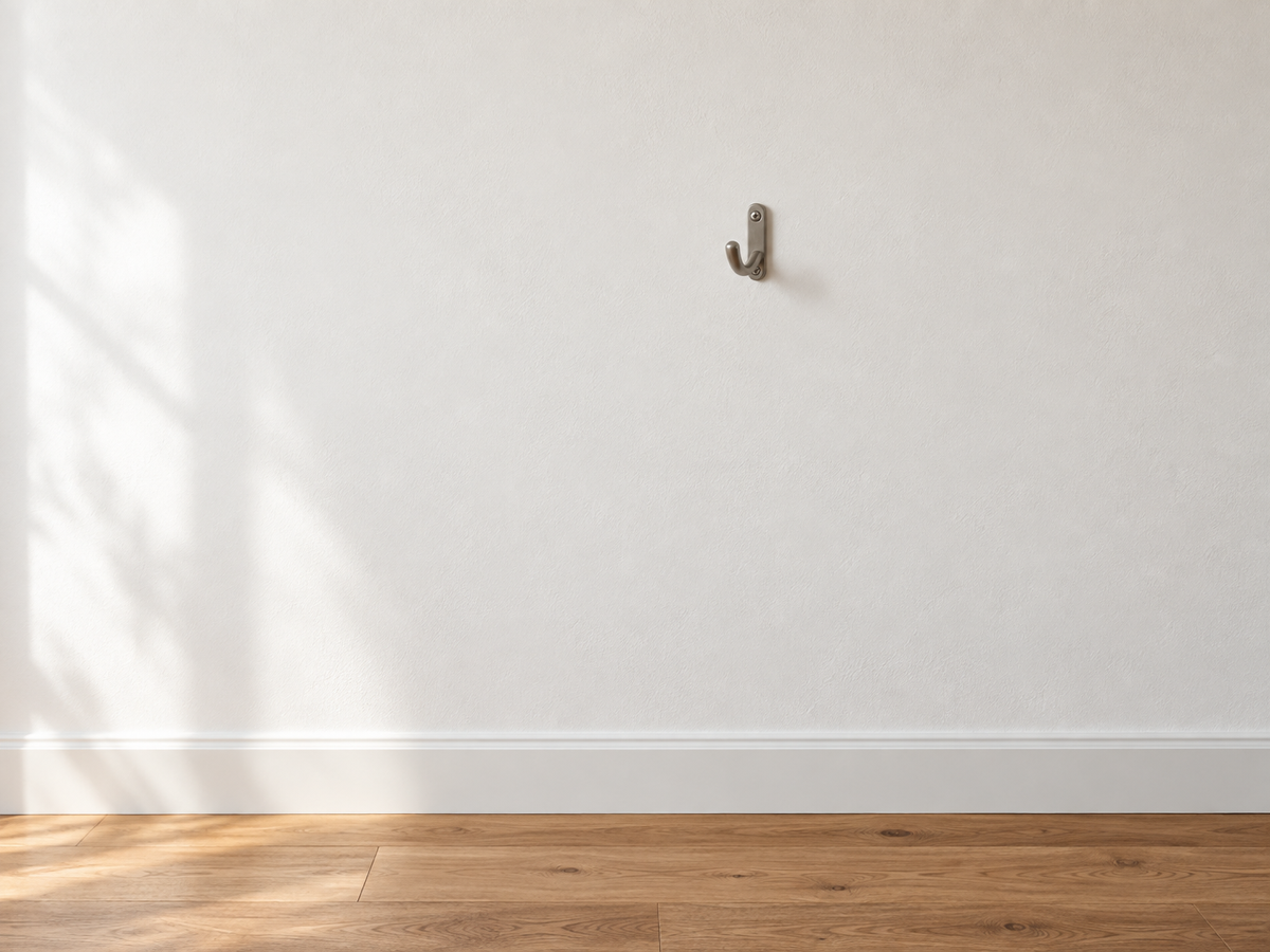 Interior wall photograph before removing a small hook and fixture